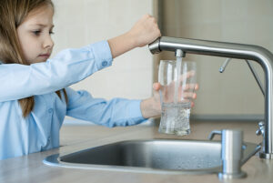 Child Pouring Glass Of Clean Water